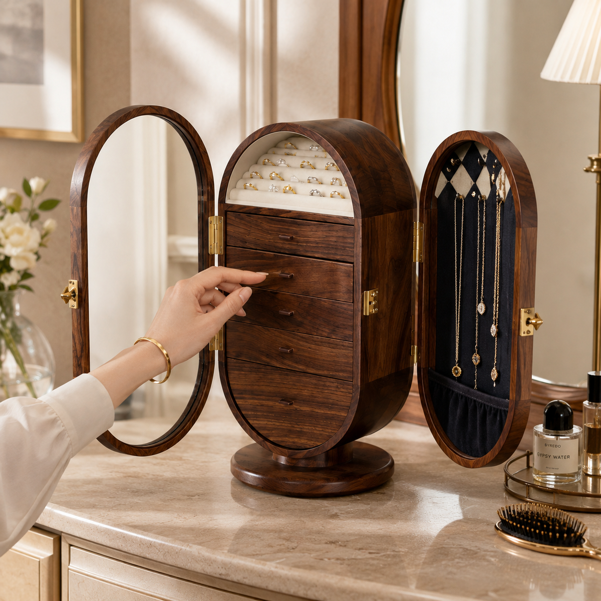 A hand opening the mirror door of the Circina walnut cabinet on a dressing table